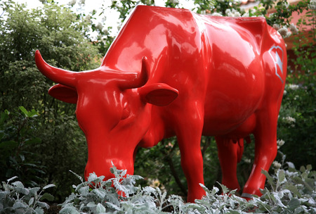 MONACO, MONTE CARLO - JULY 12, 2008:  Red cow sculpture in the park Monaco Le Jardin exotique. This is a very famous park - there are a lot of exotic plants and sculptures. Every time many people like to walk here.のeditorial素材