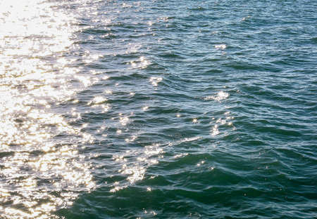 Sea background with sunbeams and waves at sunsetの写真素材