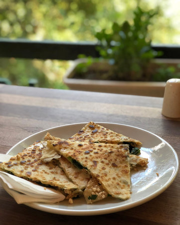 Traditional turkish tortillas with cheese and spinach on the table in the summer veranda