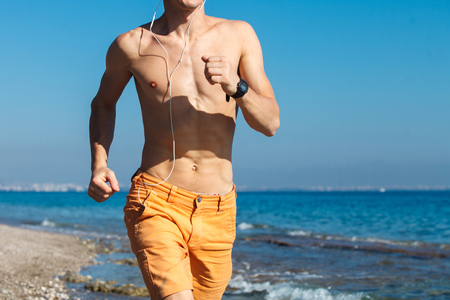 Extreme seaside sport man running on the water at sunrise harsh lightの写真素材