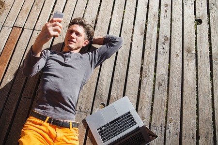 Freelance laptop computer working on the wood terrace early in the morningの写真素材