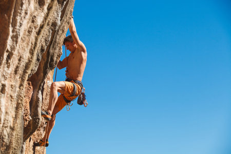 Rebelious rock climber on the wall against the blue sky - bold choice of real men. Dangerous adventure. Turkey, Geyikbayiri - Stock Image, Close-Upの写真素材