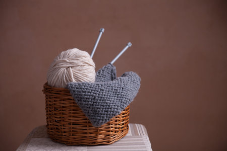 Basket witn yarn ball, knitting and needles. Close-up horiaontal photo. Freelance creative working...