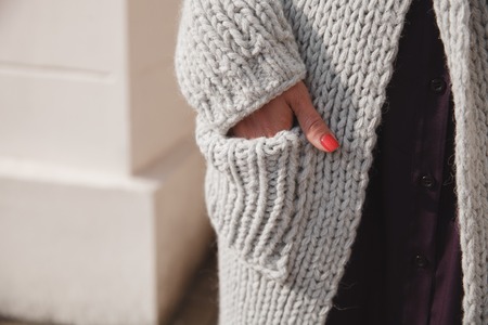 Portrait of young woman wearing colorful knitted clothes. Outdoor, street, lifestyle. Concept of freelance creative working and living.の写真素材