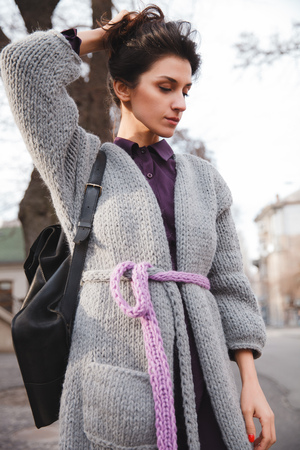 Portrait of young woman wearing colorful knitted clothes. Outdoor, street, lifestyle. Concept of freelance creative working and living.の写真素材