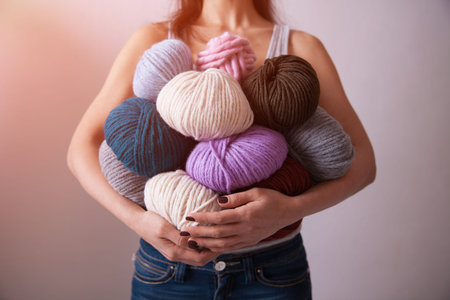 Young pretty woman holding many colorful  yarn clews. Close-up vertical photo. Concept of freelance...