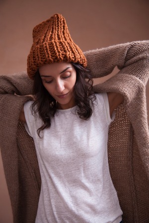 Young smiling happy woman in knitted  hat. Concept of freelance creative working and happy livingの写真素材