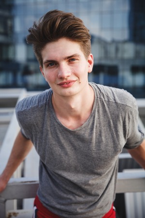 Portrait of young athlete on urban environment against office buildings before running. Front view closeup. Concept of active living, freelance, remote business, healthcare and wellbeingの写真素材