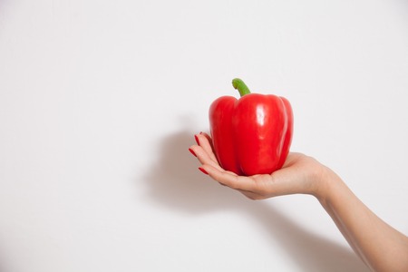 Fresh pepper on woman hands - closeup photo. Concept of vegetarian dieting, raw food ingredients, healthy and joyful livingの写真素材