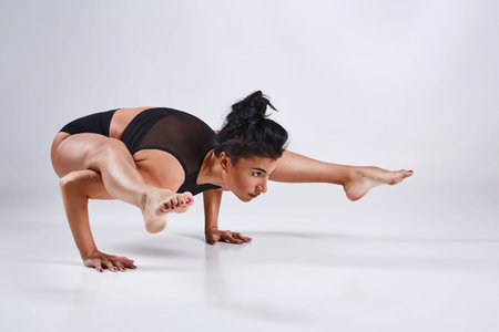 Sporty young woman doing yoga practice isolated on white background - concept of healthy life and natural balance between body and mental developmentの写真素材