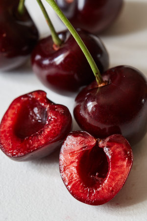 Some sweet cherries with green stems isolated on white background. Macro view, extreme close-up....