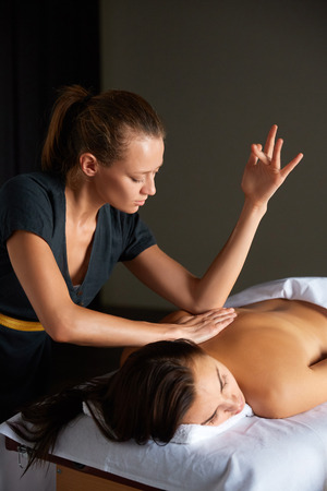 Female enjoying relaxing full body massage made made by masseuse with forearms and cubits in cosmetology spa centre. Body care, skin care, wellness, wellbeing, beauty treatment concept.の写真素材
