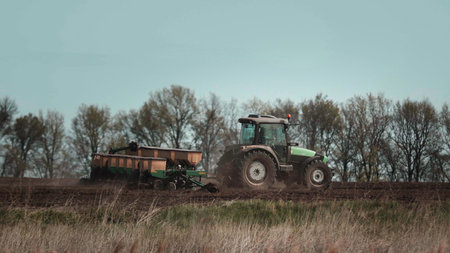 Tractors cultivates the field before seeding