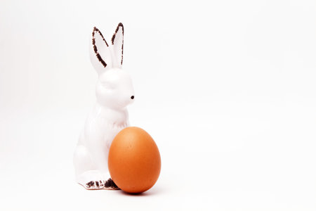 easter bunny ceramic figurine egg on white backgroundの写真素材
