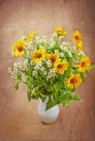 The bouquet of autumn flowers on the old canvas background, rustic style.の写真素材