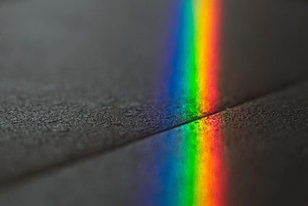 Close up macro photo of so beautiful rainbow glare spectrum lighting specular reflection on the floor. Sun ray shining through window glass that work as prism and reflex colorful spectrum on floor.の写真素材