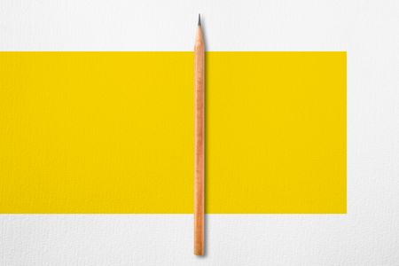 Minimalist template with copy space by top view close up photo of wooden pencil put in the center of texture white paper and combine with yellow rectangle.Flash light made pencil have smooth shadow.の写真素材
