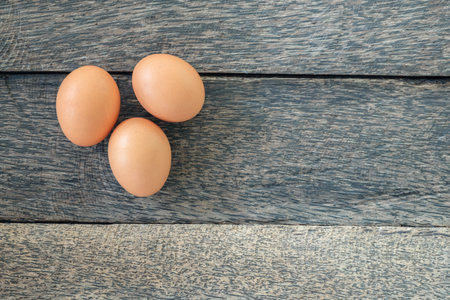 Chicken eggs on old wooden background