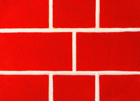 Bright red brick wall with white seams, Wall surface. Building block, background, copy space