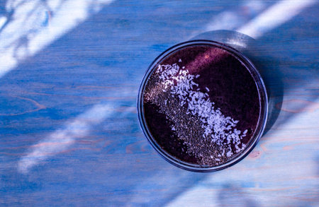 Healthy vegan blueberry smoothie breakfast with chia seeds and coconut on a purple wooden background...