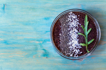 Healthy vegan blueberry smoothie breakfast with chia seeds and coconut on a blue wooden background
