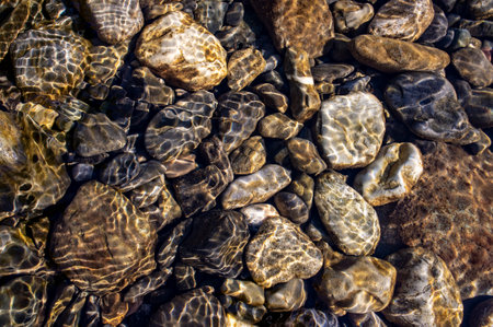 Background from pebble stone in water in sunlight. Wallpaperの写真素材