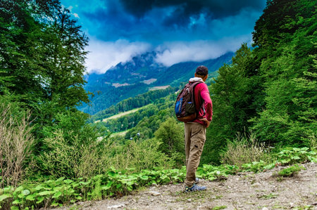 Young caucasian man on trekking in the mountains with a backpack. Active lifestyle. Travel to wild places of nature.の写真素材
