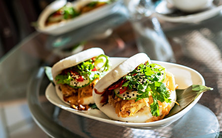 Two Vegan bao sandwich with tofu, kimchee and parsley on glass table in cafe healthy vegetarian food