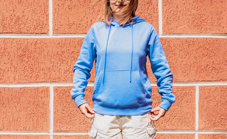 Smiling young woman in blue purple hoodie on red background copy space mockup friendly