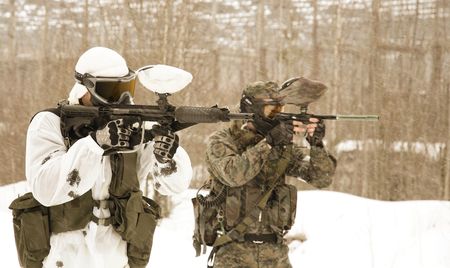 armed men in a camouflage play a paintballの写真素材