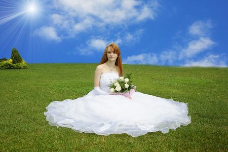 beautiful bride sits on a green grassの写真素材