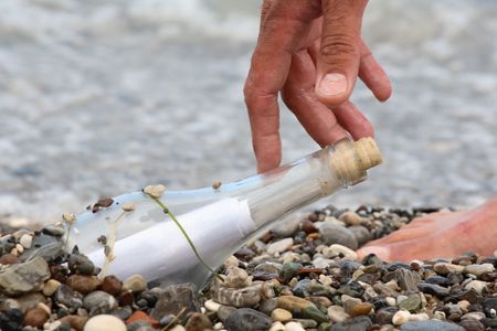 Transparent glass bottle with a note on seacoastの写真素材