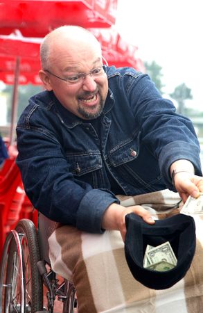 man-beggar in an invalid carriage demands moneyの写真素材