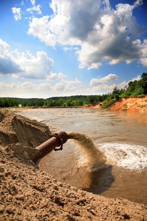 sewage flowing from a pipe in the riverの写真素材