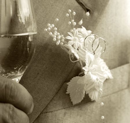 Glass with champagne in a hand at the groom.の写真素材
