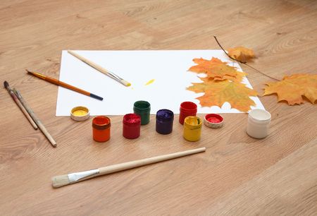 Multi-coloured gouache, brushes, clean sheet and maple leaf. We draw autumn.の写真素材