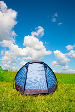 Bright tourist tent on green grass against the blue sky.の写真素材