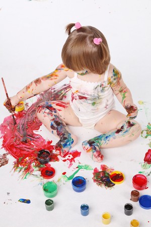 little girl bedaubed with bright colorsの写真素材