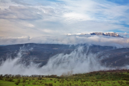 Beautiful landscape with a fog and mountains on a background