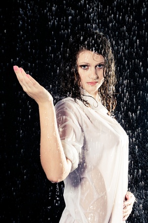 beautiful girl in the rain against a dark backgroundの写真素材