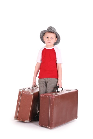 boy in a hat has control over old suitcases. The tourism and rest concept.の写真素材