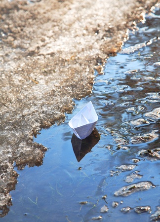 paper ship floats on a spring streamの写真素材