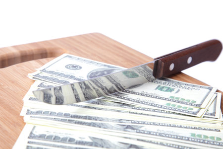knife cuts a pack of dollarsの写真素材