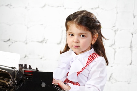 three-year girl prints on the old typewriterの写真素材