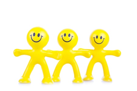 Three smiling toy little men on a white backgroundの写真素材