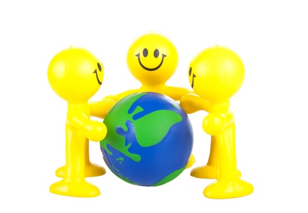 Smiling toy little men hold globe. It is isolated, a white backgroundの写真素材