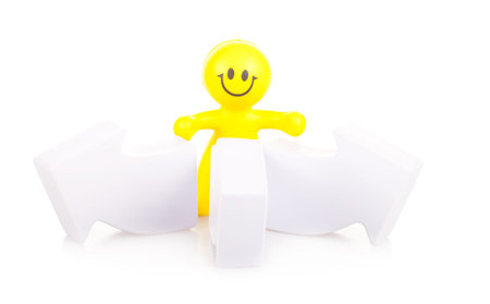 One smiling toy little man costs near the arrows specifying a direction. The concept of a difficult choice.の写真素材