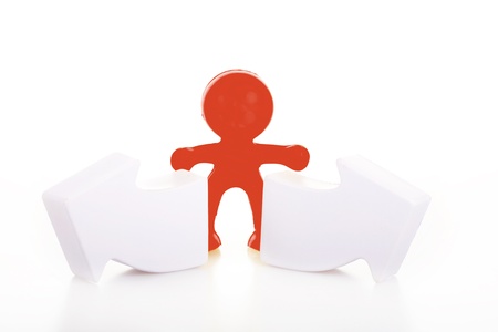 One smiling toy little man costs near the arrows specifying a direction. The concept of a difficult choice.の写真素材