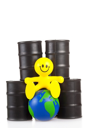 toy smiling little man sits next on butts to oil the globe. The world supremacy concept oil-extracting the companiesの写真素材