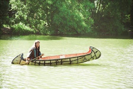 North American Indian floats down the river on a canoeの写真素材